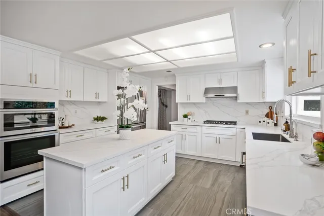 a kitchen with white cabinets stainless steel appliances and sink