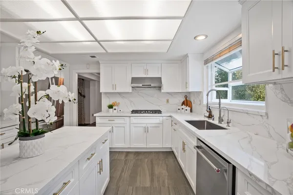 a kitchen with white cabinets and appliances