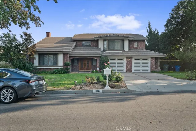 a front view of a house with a garden and plants