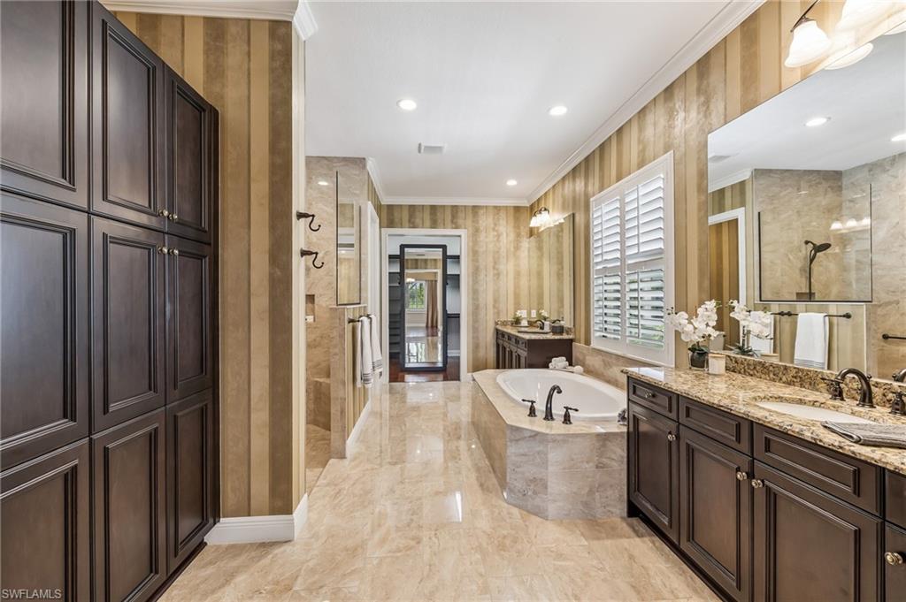 12449 Lockford Lane Naples, FL 34120 - Photo 17 of 45 a large spacious bathroom with a double vanity sink a mirror and a bathtub