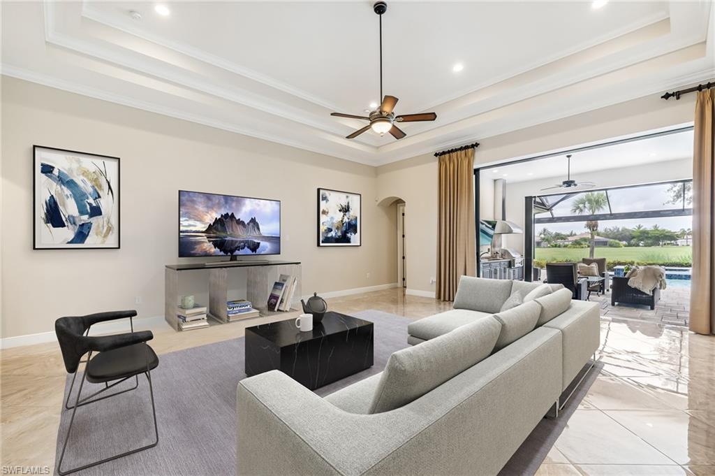 12449 Lockford Lane Naples, FL 34120 - Photo 2 of 45 a living room with furniture a chandelier and a large window