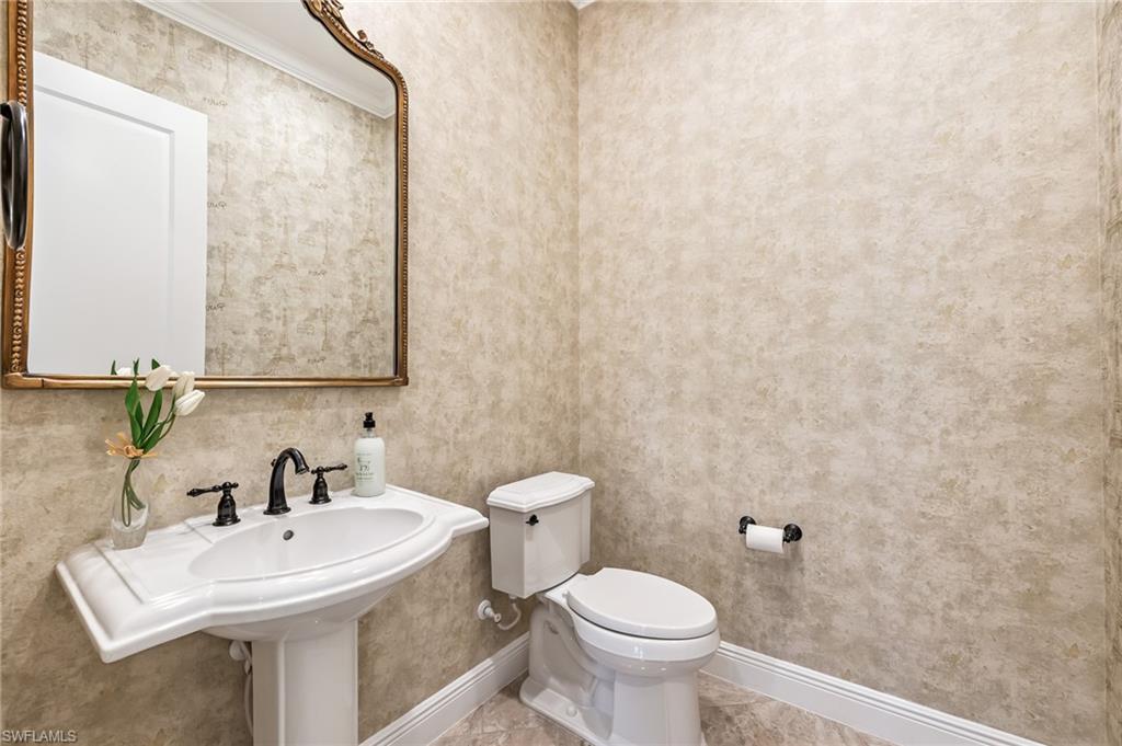 12449 Lockford Lane Naples, FL 34120 - Photo 24 of 45 a bathroom with a sink a toilet and mirror