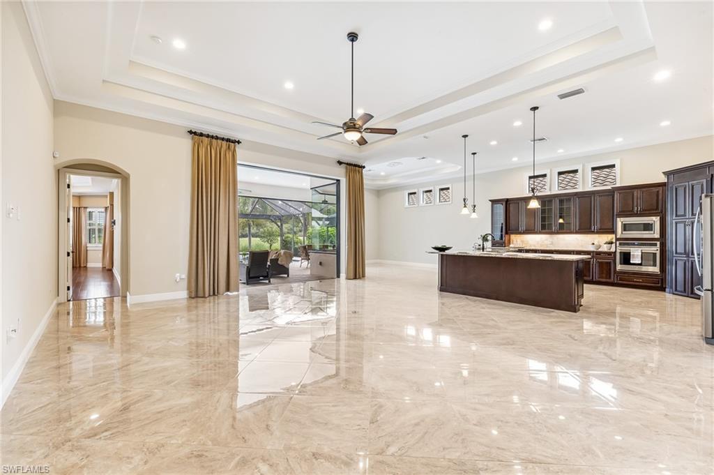 12449 Lockford Lane Naples, FL 34120 - Photo 4 of 45 a view of a kitchen with kitchen island a counter top space a sink stainless steel appliances and cabinets