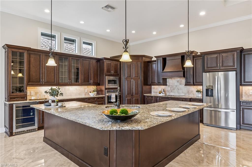 12449 Lockford Lane Naples, FL 34120 - Photo 5 of 45 a kitchen with stainless steel appliances granite countertop a sink refrigerator and cabinets