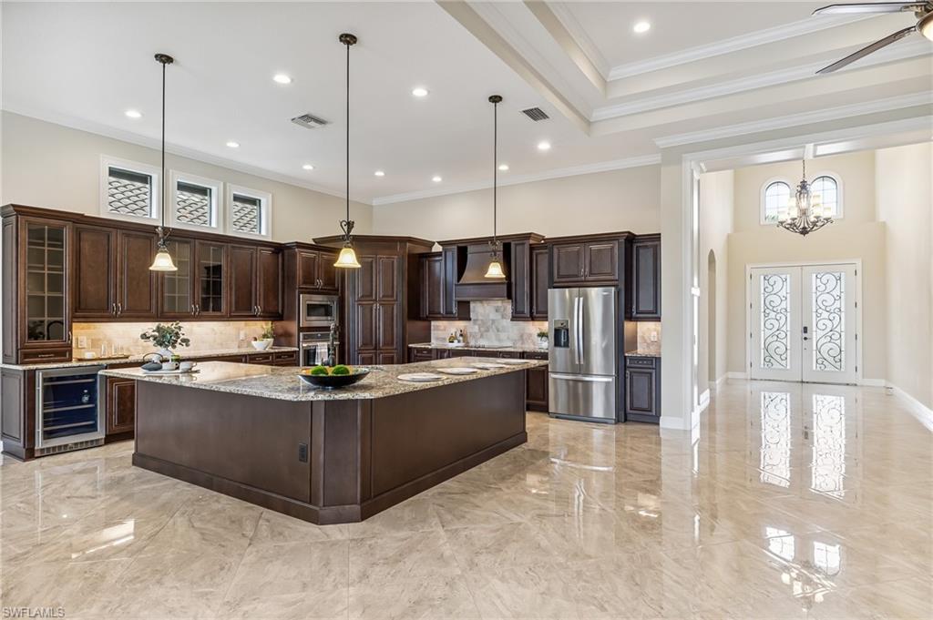 12449 Lockford Lane Naples, FL 34120 - Photo 6 of 45 a view of kitchen with stainless steel appliances kitchen island granite countertop a stove and a view of living room