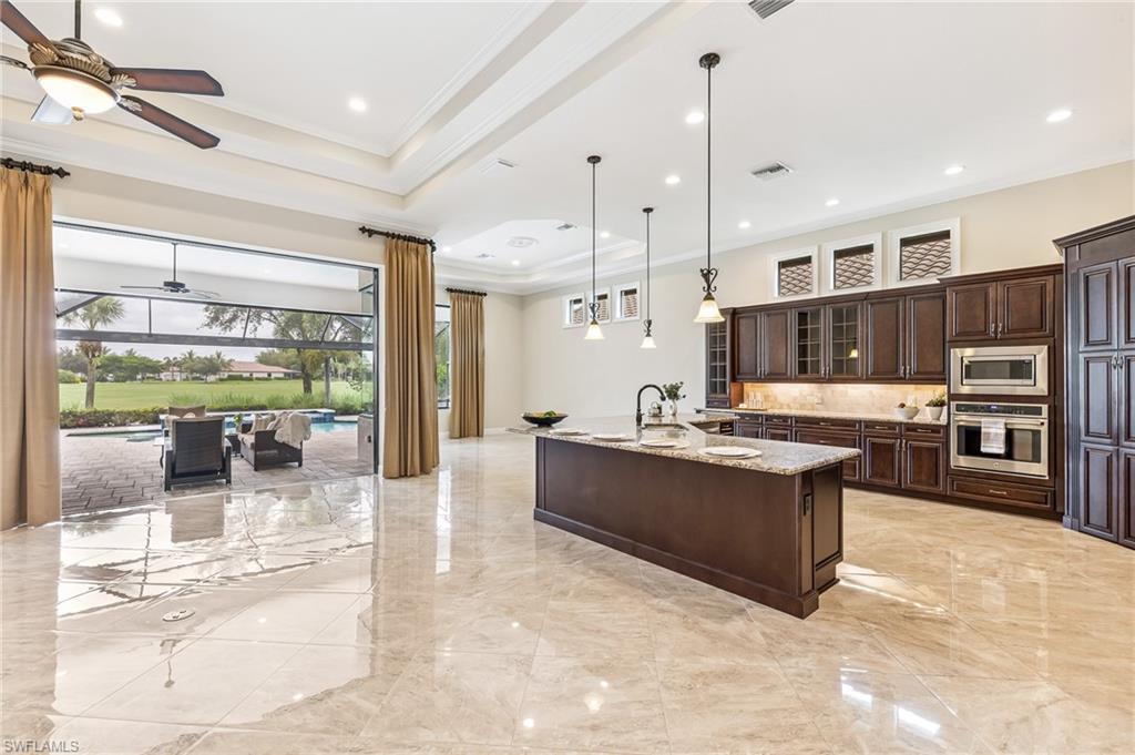 12449 Lockford Lane Naples, FL 34120 - Photo 7 of 45 a large kitchen with stainless steel appliances kitchen island granite countertop a large counter top a stove and a chandelier