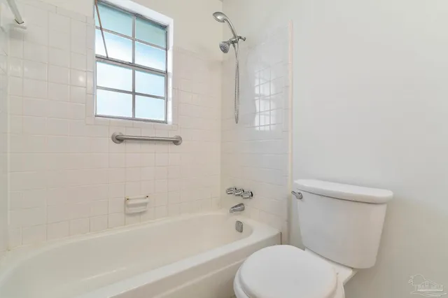 a white toilet sitting next to a bath tub