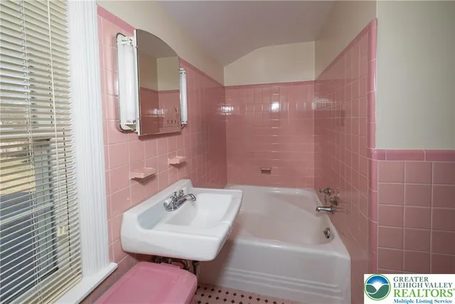 a bathroom with a sink a toilet a mirror and bathtub