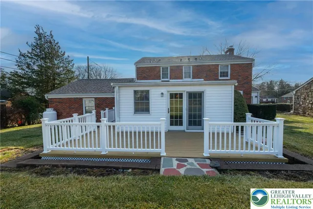 a view of a house with a deck and a yard