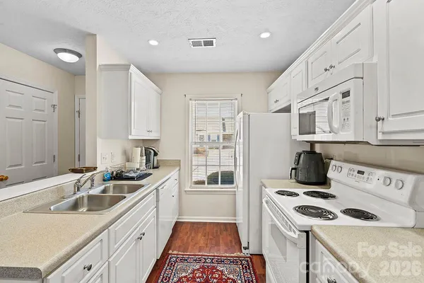 a kitchen that has a sink a stove and a oven