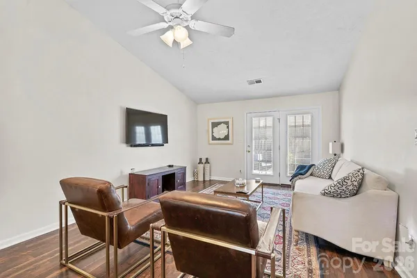 a living room with furniture a chandelier and a flat screen tv