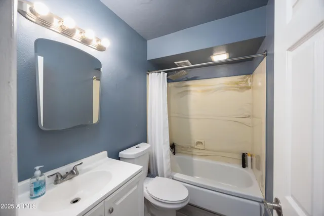 a bathroom with a sink vanity mirror and toilet