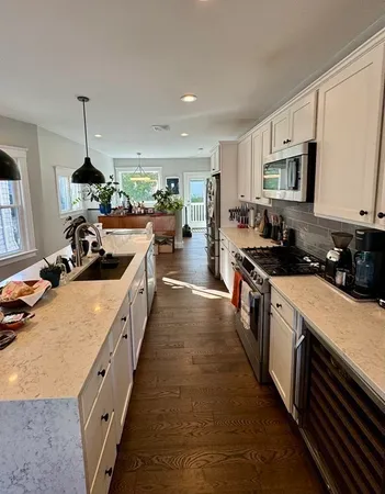 a kitchen with kitchen island granite countertop lots of counter top space a sink and appliances