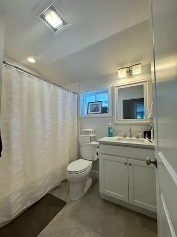 a bathroom with a toilet sink and mirror
