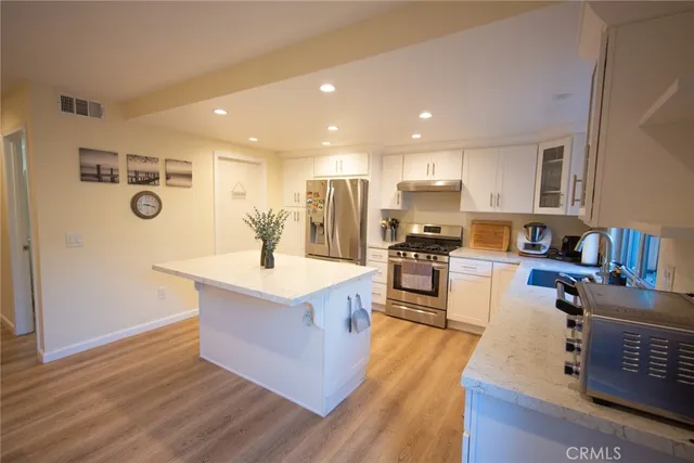 a kitchen with stainless steel appliances granite countertop a sink stove and refrigerator