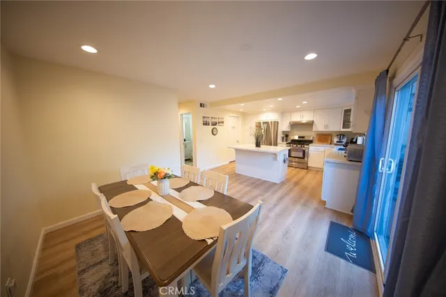 a view of a dining room with furniture a rug and wooden floor
