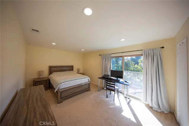 a bedroom with a bed and large windows