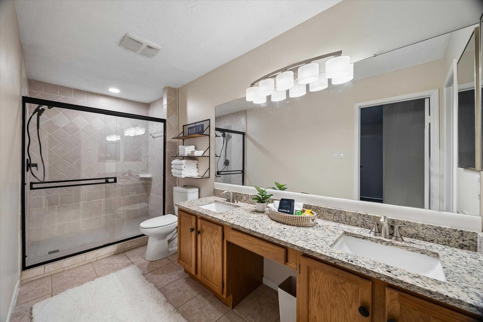 30 Camberwell Court The Woodlands, TX 77380 - Photo 19 of 26 a bathroom with a granite countertop sink a toilet a mirror and shower