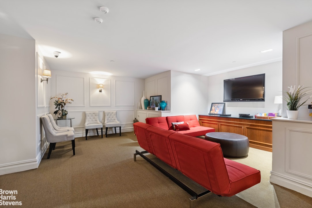 220 West 148th Street, Unit 4B Manhattan, NY 10039 - Photo 11 of 15 a living room with furniture and a flat screen tv