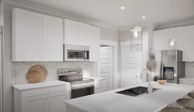 a kitchen with stainless steel appliances a refrigerator a sink a stove and white cabinets