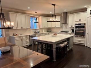 2500 Walnut View Drive Howell, MI 48855 - Photo 12 of 41 Kitchen with white cabinetry, wall chimney range hood, appliances with stainless steel finishes, and recessed lighting