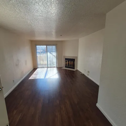a view of kitchen with stainless steel appliances granite countertop a refrigerator and a stove