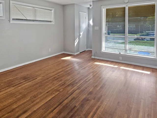 a view of a room with wooden floor and a window