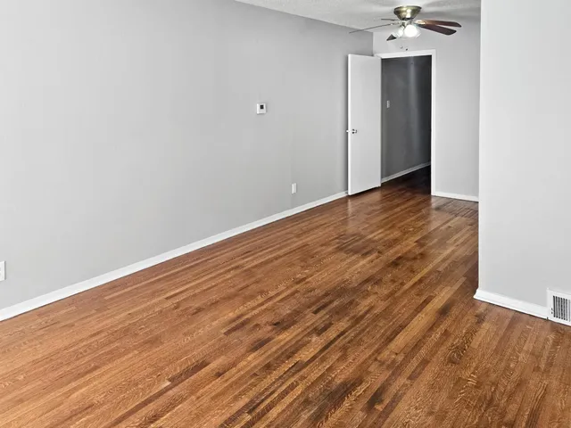 a view of an empty room with wooden floor