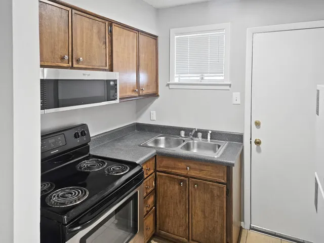 a kitchen with granite countertop a stove and a sink