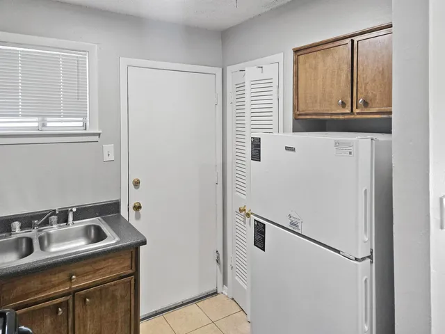 a kitchen with a sink a refrigerator and cabinets
