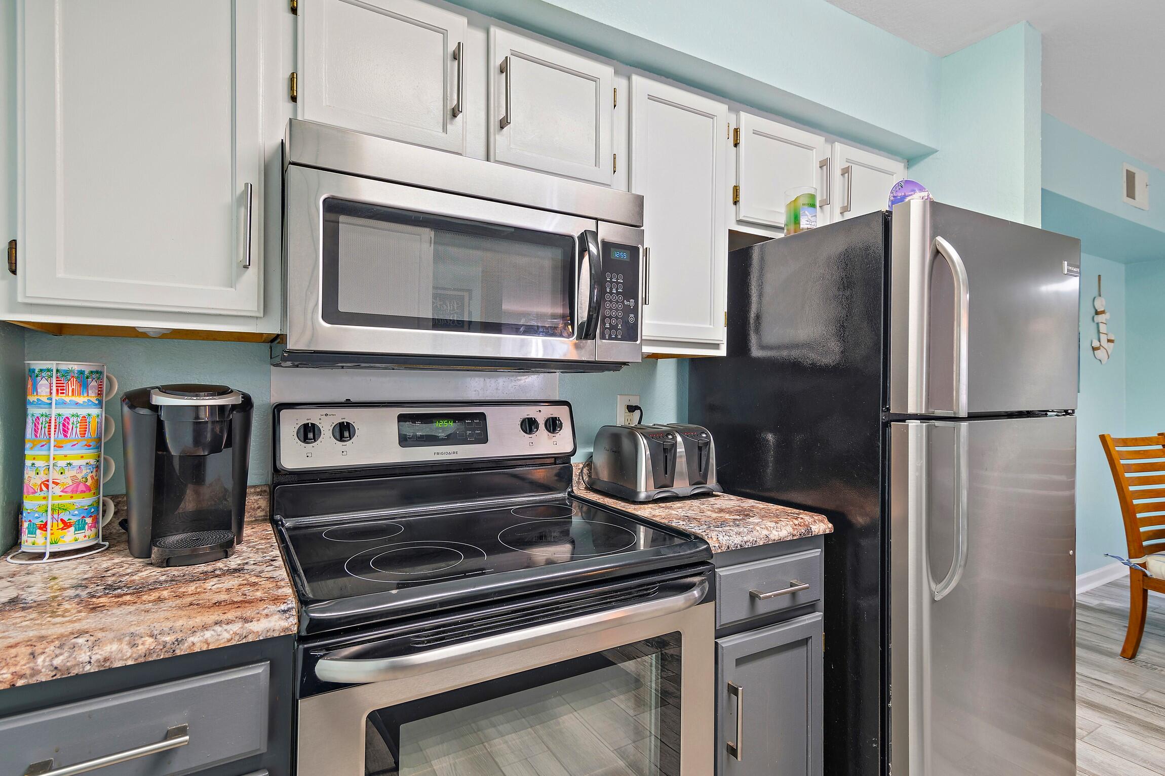 4010 Dancing Cloud Court, Unit 404 Destin, FL 32541 - Photo 16 of 44 a kitchen with stainless steel appliances granite countertop a refrigerator stove and microwave