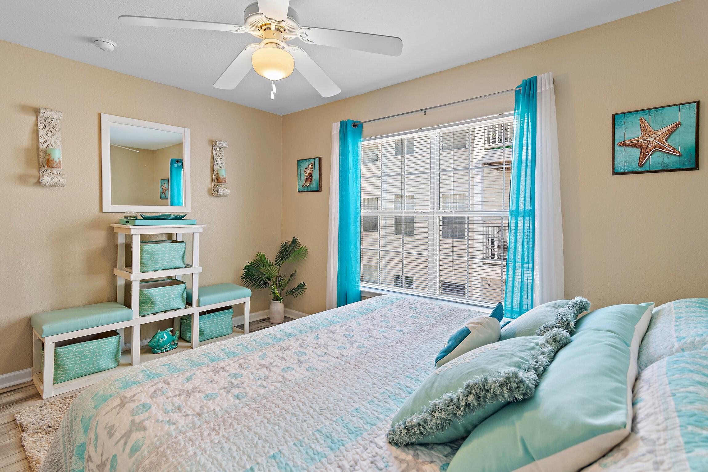 4010 Dancing Cloud Court, Unit 404 Destin, FL 32541 - Photo 18 of 44 a bedroom with a bed and a chandelier