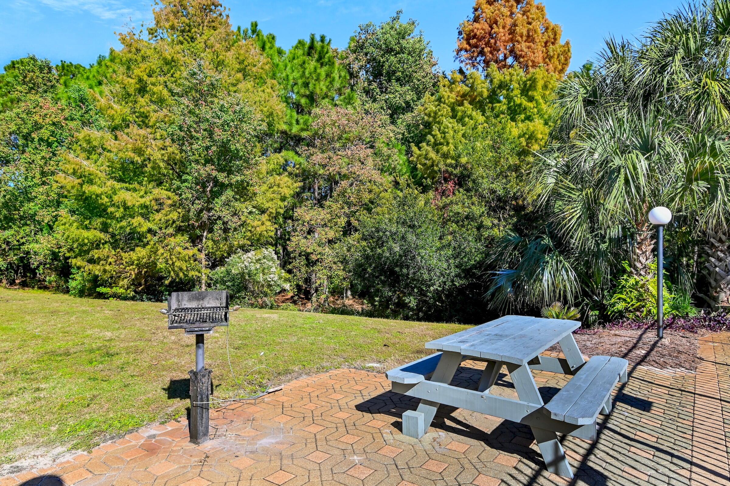 4010 Dancing Cloud Court, Unit 404 Destin, FL 32541 - Photo 30 of 44 a backyard of a house with table and chairs