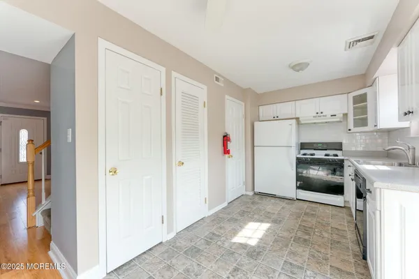 a kitchen with granite countertop a refrigerator and a sink