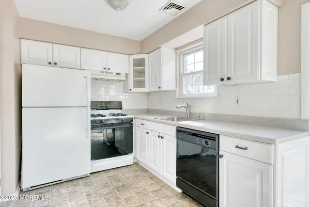 a kitchen with white cabinets and white appliances