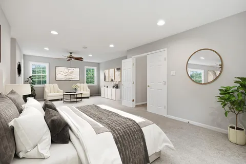 a spacious bedroom with a bed and a potted plant
