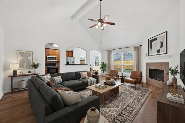a living room with furniture a fireplace and a chandelier