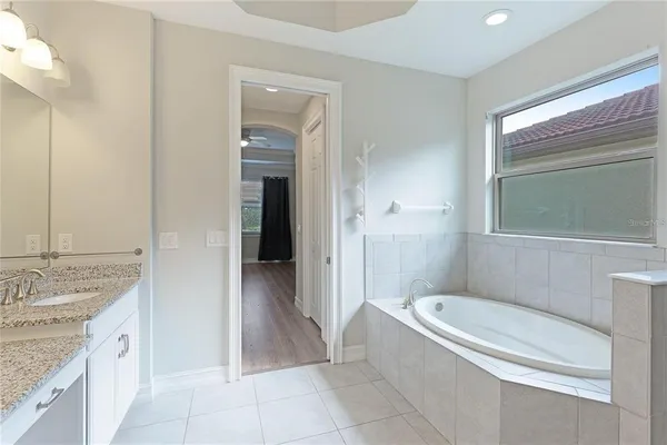 a kitchen with kitchen island granite countertop a sink white cabinets and stainless steel appliances