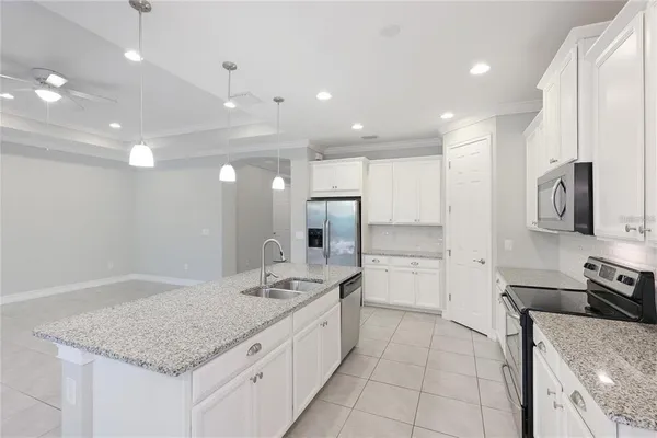 a large kitchen with stainless steel appliances granite countertop a sink and cabinets