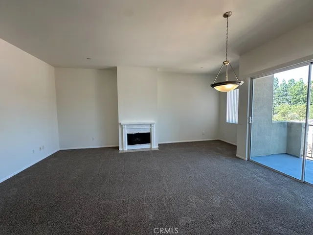 a view of an empty room with a fireplace and a window