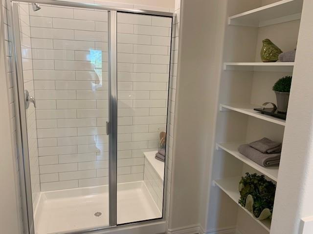 712 Feldspar Way Princeton, TX 75407 - Photo 6 of 12 Walk-in shower featuring subway tile surround, clear glass enclosure, and a built-in shower bench