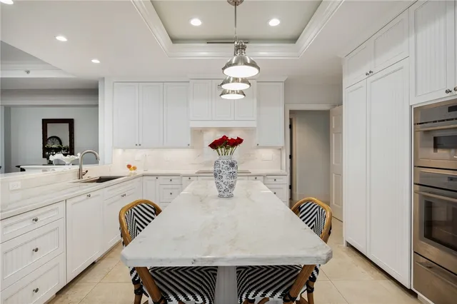 a kitchen with a table chairs and white cabinets