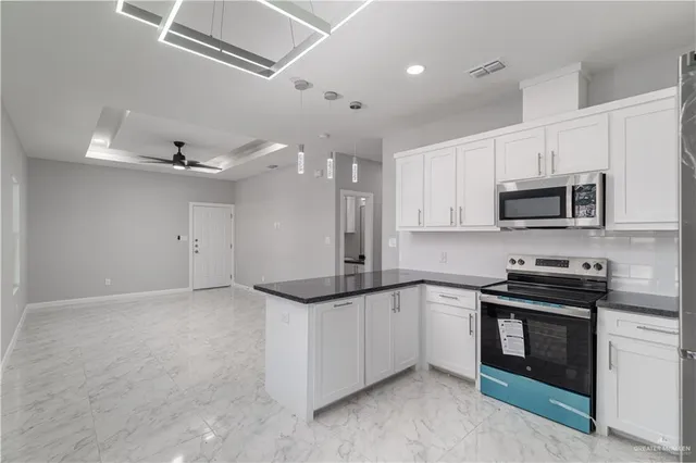 a kitchen with granite countertop a sink and stainless steel appliances