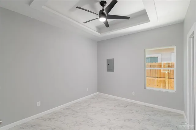 an empty room with a window and a fan