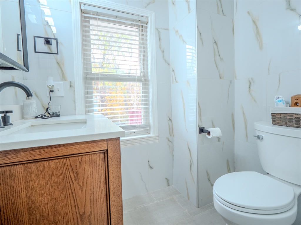 51 Lancaster Road Dedham, MA 02026 - Photo 21 of 41 a bathroom with a toilet a sink and a window