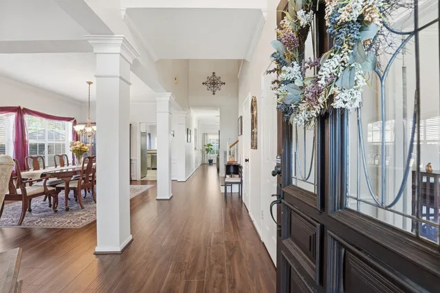 a view of a hallway with wooden floor and furniture