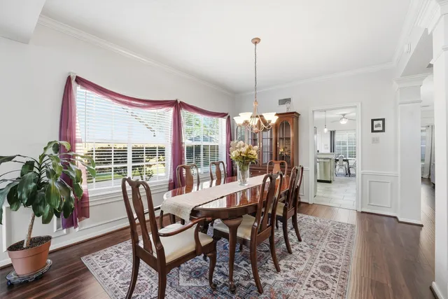 a view of a dining room and livingroom with furniture wooden floor a chandelier