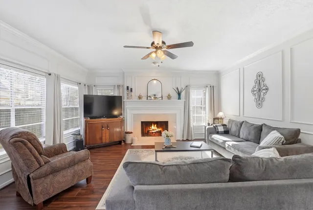 a living room with furniture a fireplace and a flat screen tv