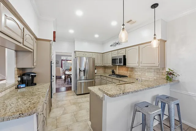 a kitchen with stainless steel appliances granite countertop a sink refrigerator and cabinets