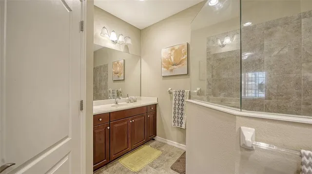 a bathroom with a double vanity sink mirror and shower